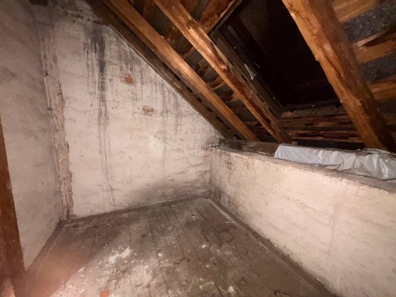 Attic in a family house with an old wooden floor and a slanted ceiling.