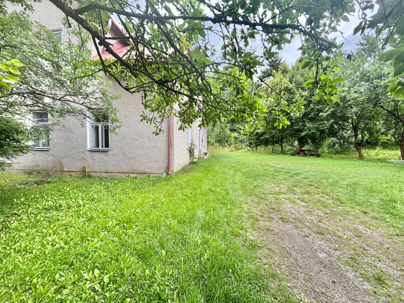 A family house in Makov on Centrum Street surrounded by a garden and trees.