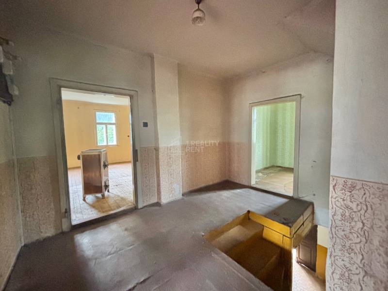 A hallway in a family house with a view of two rooms, stairs down.