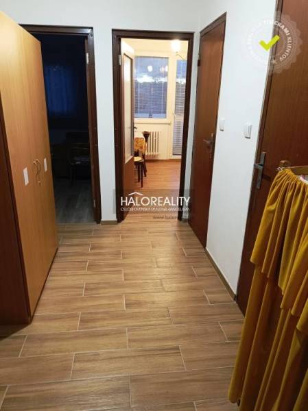 A hallway and a 2-room apartment with ceramic tiles, wooden doors, and access to the rooms.