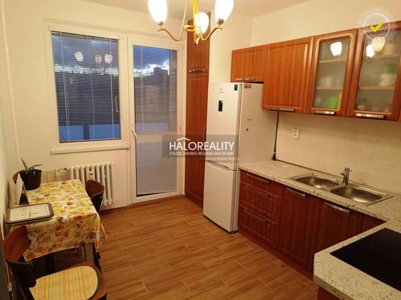 Kitchen and space in a 2-room apartment with a wooden kitchen unit and table.