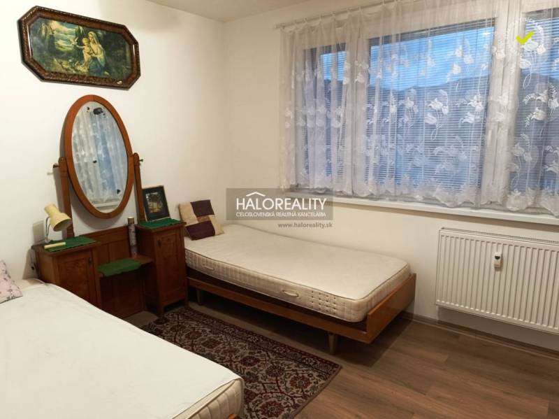Two beds, a mirror, paintings, and a carpet in a room in a two-room apartment.