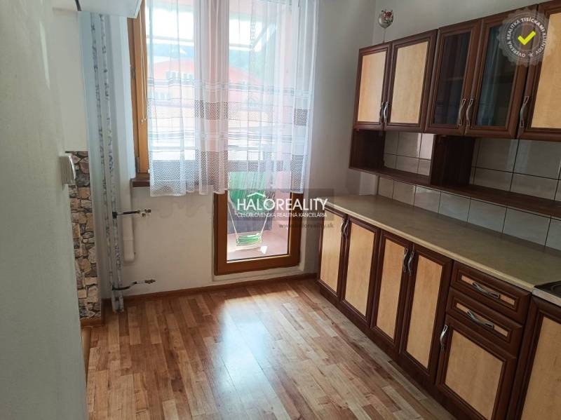 A kitchen in a 3-room apartment with a wooden floor and a kitchen unit.