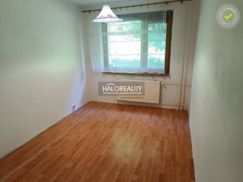 A room with laminate flooring and a large window in a 3-room apartment.