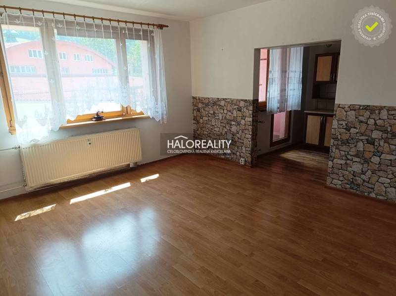 Sunny living room with laminate flooring and stone cladding in a 3-room apartment.