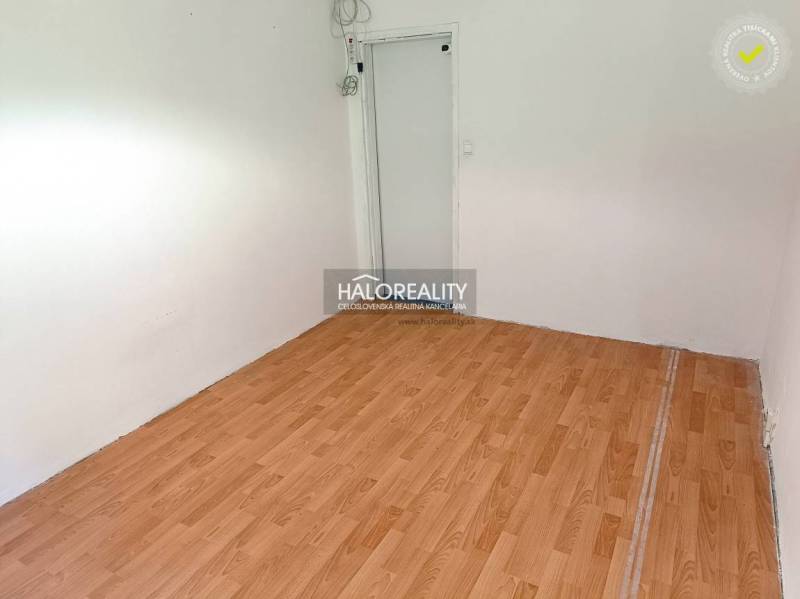 An empty room in a 3-room apartment with laminate flooring and white walls.