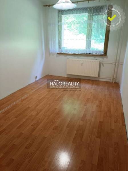 A room with a light laminate floor and a window in a 3-room apartment.