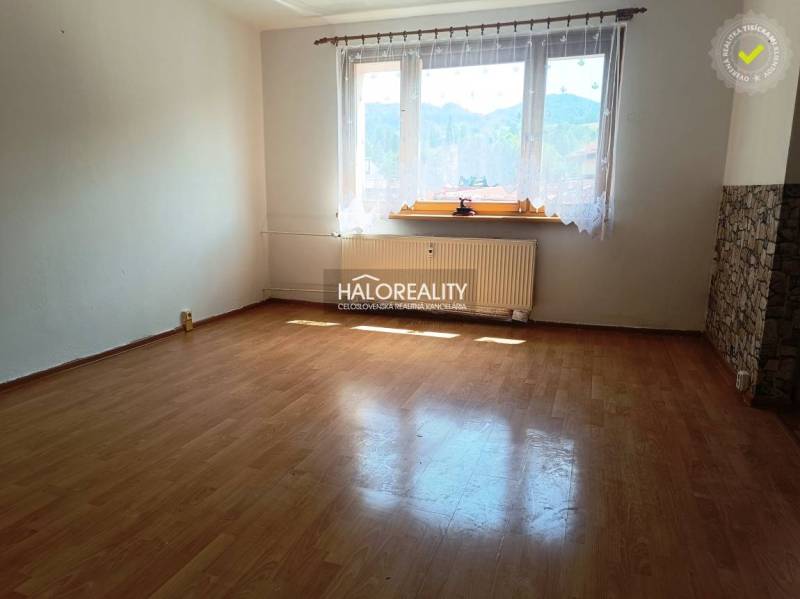 A spacious room with wooden flooring and a large window in a 3-room apartment.