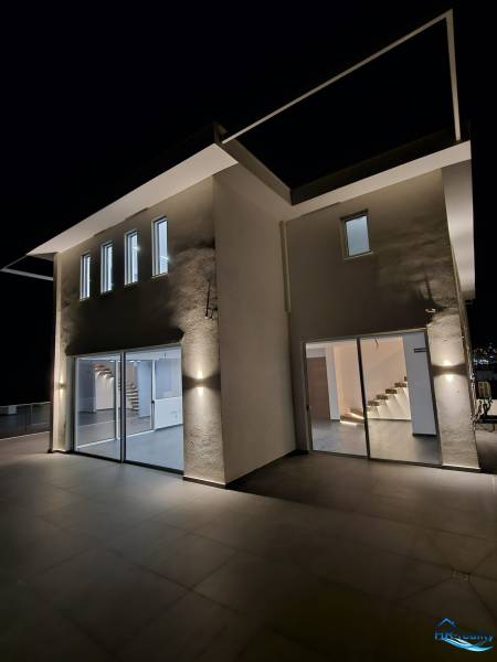 The exterior of a holiday apartment in Sarandë illuminated by night light.