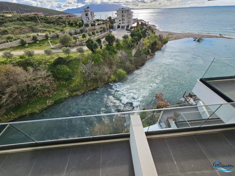 View from a holiday apartment in Sarandë of the coast and nearby buildings.