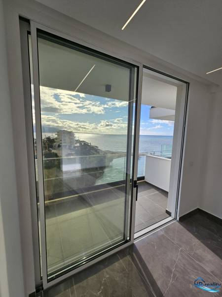 Glass sliding doors with a view of the sea in a holiday apartment near Sarandë.