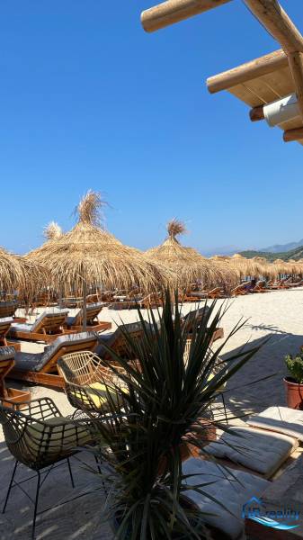 Beach loungers and straw umbrellas in a holiday apartment near Sarandë.