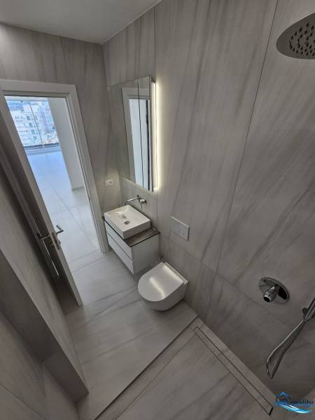Bathroom of the holiday apartment with a sink, shower, and tasteful lighting.