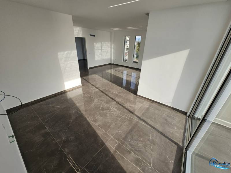 Interior of a vacation apartment with large windows and glossy tiles.