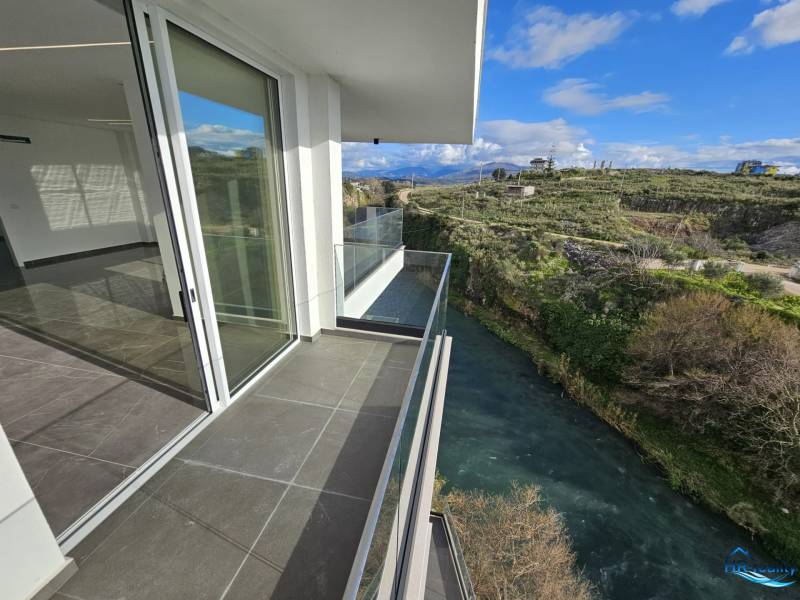 The balcony of a holiday apartment in Sarandë with a view of the river and the countryside in the background.
