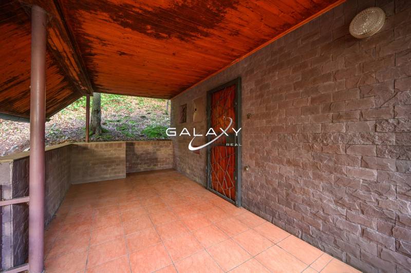 Outdoor terrace of the cottage in Ružiná with a wooden ceiling and tiles.