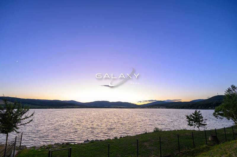 A lake at sunset, tranquil nature around Ružiná and cottages.