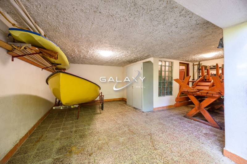 Storage space in a cabin with a boat and a wooden table in the corner of the room.