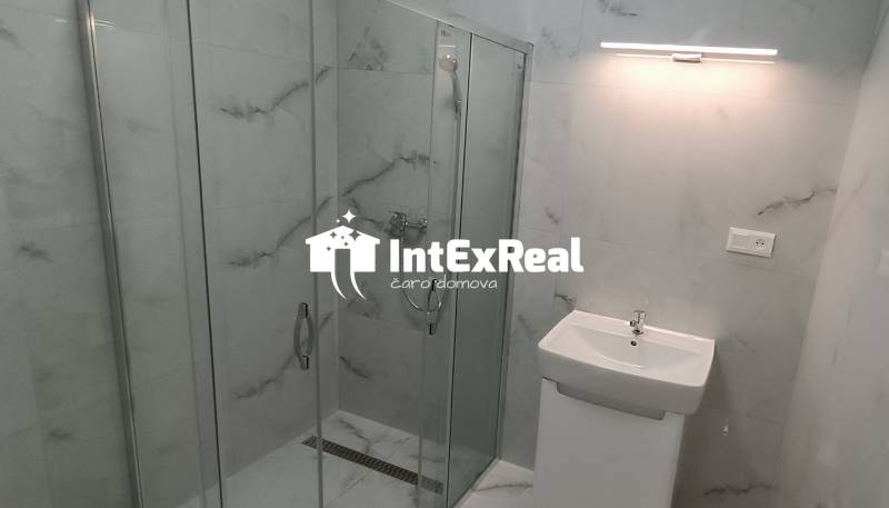 Bathroom with a glass shower enclosure in a 2-room apartment.