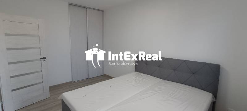 Bedroom with a double bed and a wardrobe in a two-room apartment.