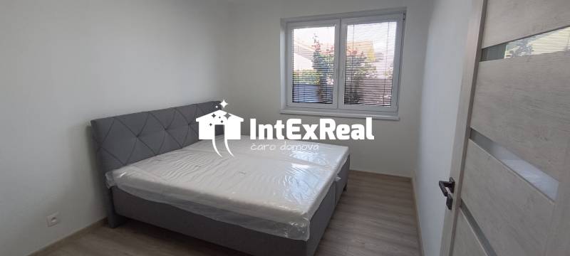 A bedroom with a bed and a window in a 2-room apartment, light walls and floor.