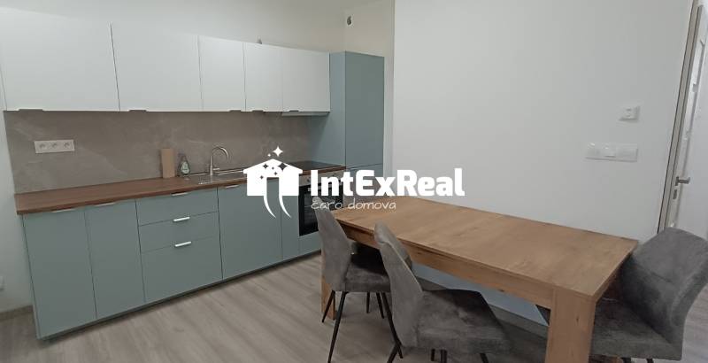 A kitchen with a dining table and chairs in a two-room apartment.