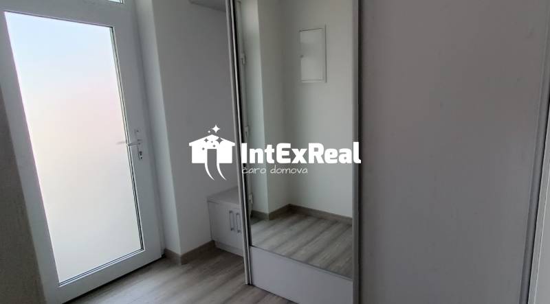 The entrance hall of a 2-room apartment with white doors and a built-in wardrobe.