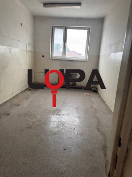 Empty commercial spaces with a window and gray floor.