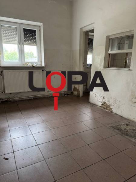 Empty commercial space with a window and a radiator.