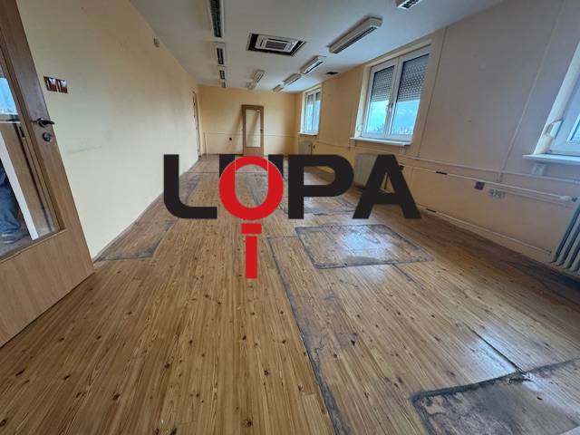 Space for rent in a building with wooden flooring, offered by a real estate agency.