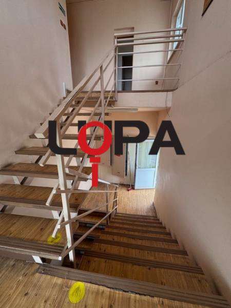 A staircase in a building with a wooden floor and metal railing.