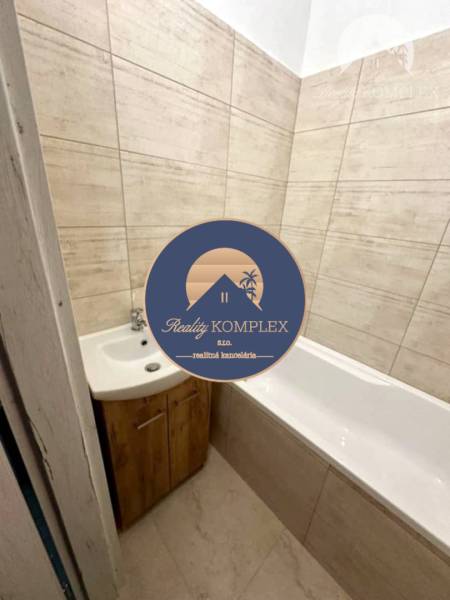 Bathroom in a 2-room apartment with a bathtub and a sink in a wooden decor.