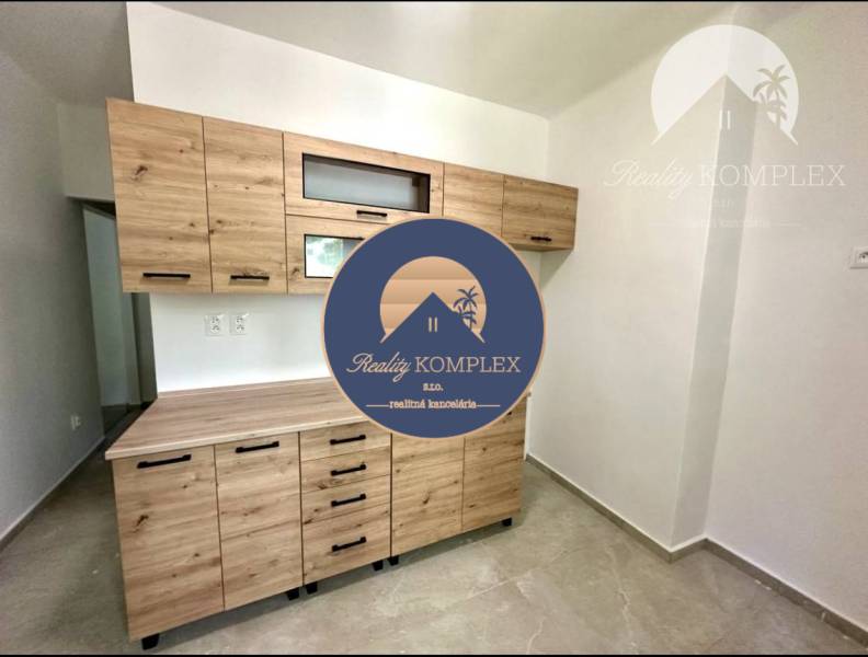 Kitchen in a 2-room apartment with a wooden cabinet and ceramic floor.