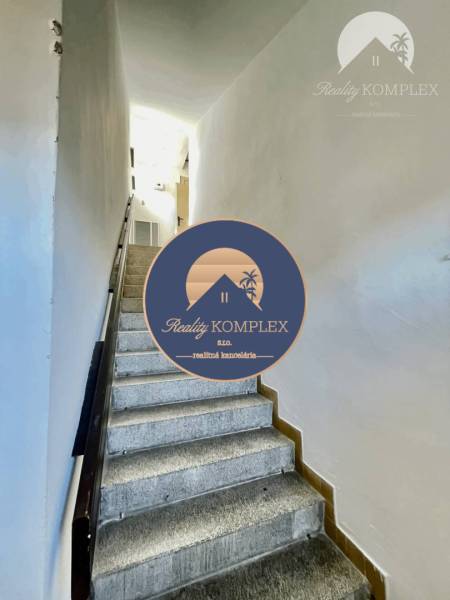 A staircase leading to the upper floor within a 2-room apartment.
