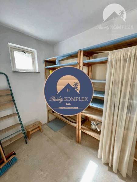 Storage space in a 2-room apartment with shelves and a window, suitable for storage.