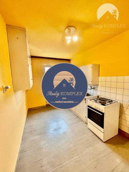 A kitchen with a gas stove and storage spaces in a 2-room apartment.