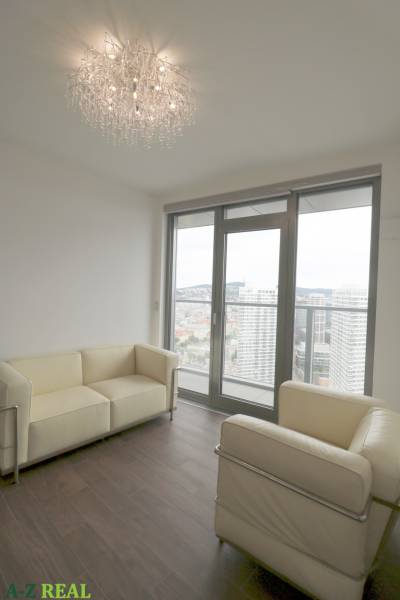 Living room with leather sofas and large windows in a 3-room apartment.