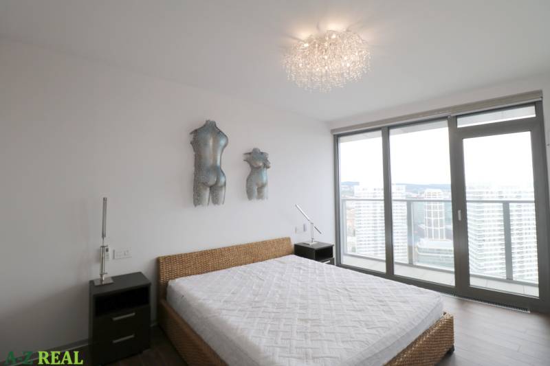 Bedroom with a bed and art, large window with a view, 3-room apartment.