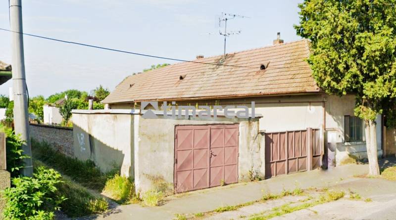 A family house in Reca with a garage and an older roof.