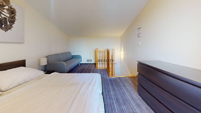 Bedroom in a 2-room apartment with a bed, sofa, and dresser.
