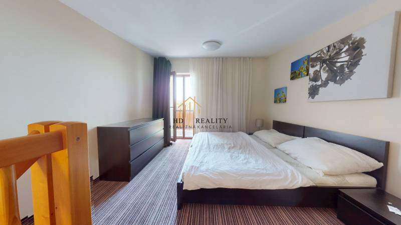Bright bedroom in a two-room apartment with a large bed, wardrobe, and decoration.