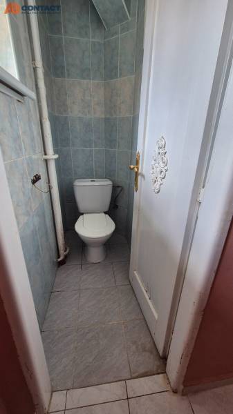 A bathroom tiled in a 3-room apartment with closed doors.