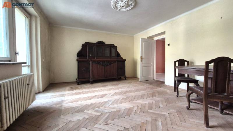 A room in a 3-room apartment with wooden furniture and parquet flooring.