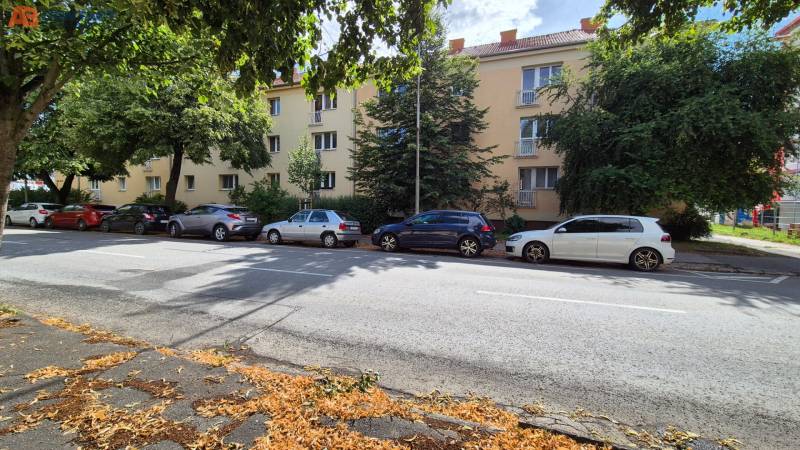 The building on Pod Párovcami Street in Piešťany, surrounded by trees and parked cars.