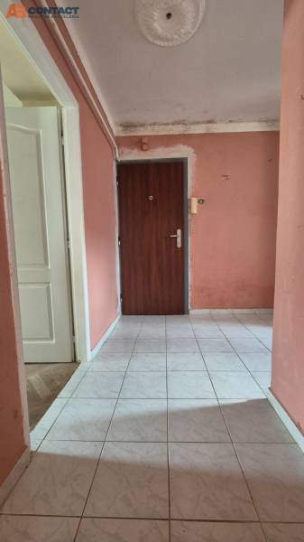 Entrance hallway with light-colored tiles and pink walls in a 3-room apartment.