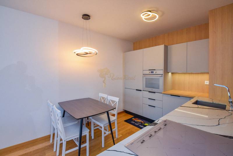 A kitchen in a 3-room apartment with light furniture and wooden flooring.