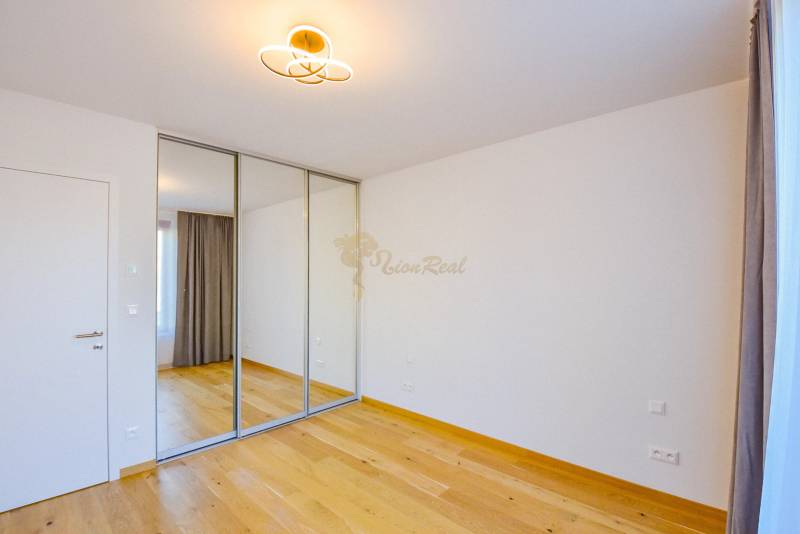 A room with a wooden floor, a mirrored wardrobe, and a curtain in a 3-room apartment.