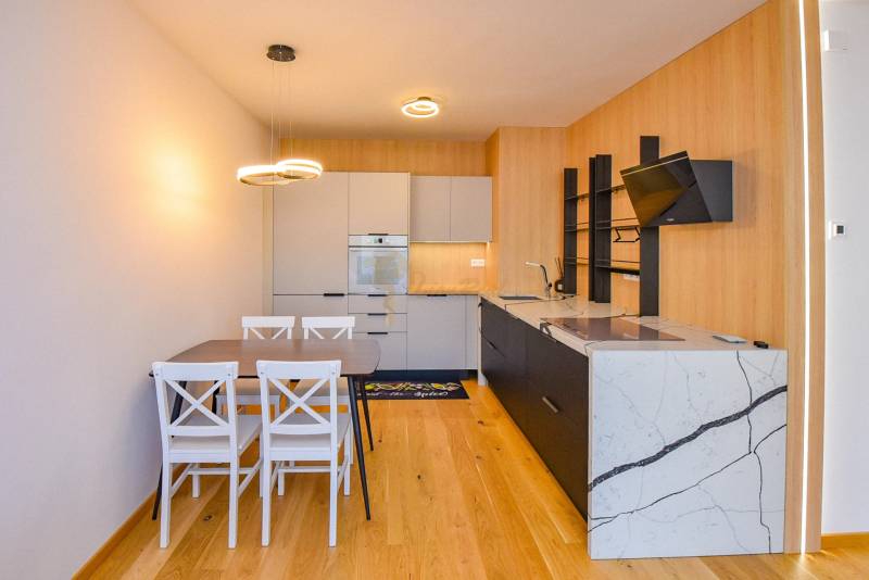 Kitchen in a 3-room apartment, wooden floor, dining table for four people.