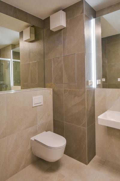 Bathroom with a wall-hung toilet and a shower in a 3-room apartment.