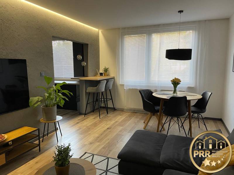 Living room of a 3-room apartment with a dining table and a bar counter.